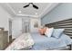 Beautiful bedroom with a ceiling fan, blue accent wall, and large bed with colorful pillows at 1425 Park Beach Cir # 127, Punta Gorda, FL 33950