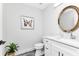 Stylish powder room with a round gold mirror, butterfly artwork, and marble-style vanity at 1425 Park Beach Cir # 127, Punta Gorda, FL 33950