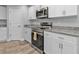 Modern kitchen featuring stainless steel appliances, granite counters, and white cabinets with sleek hardware at 14516 San Domingo Blvd, Port Charlotte, FL 33981