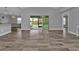 Spacious living room featuring wood-look tile and access to a screened outdoor area at 14516 San Domingo Blvd, Port Charlotte, FL 33981