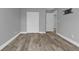 Simple bedroom with wood-look floors and double doors leading to another room at 14516 San Domingo Blvd, Port Charlotte, FL 33981