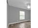 Bedroom with wood-look floors, ceiling fan, and a window with blinds at 14516 San Domingo Blvd, Port Charlotte, FL 33981