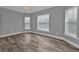 Bright bedroom with wood-look tile floors, ceiling fan, and multiple windows at 14516 San Domingo Blvd, Port Charlotte, FL 33981