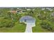 An aerial view showing a house, driveway, and surrounding landscape at 14516 San Domingo Blvd, Port Charlotte, FL 33981