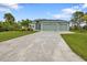Exterior of a house with light green walls, a three-car garage, and a large driveway at 14516 San Domingo Blvd, Port Charlotte, FL 33981