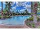 Resort-style community pool with lush landscaping, inviting seating, and beautiful palm trees at 1289 Ballota Ln, North Port, FL 34289