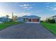 Modern home exterior with stone accents and a wood garage door at 6100 Riverside Dr, Punta Gorda, FL 33982