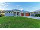 Modern home with stone and metal exterior, a wooden garage door and manicured lawn at 6100 Riverside Dr, Punta Gorda, FL 33982