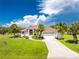 Single-story home with attached garage, lush landscaping, and terracotta roof at 16407 San Edmundo Rd, Punta Gorda, FL 33955