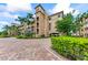 Three-story building with a Mediterranean design, lush landscaping, and parking area at 89 Vivante Blvd # 305, Punta Gorda, FL 33950
