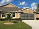Tan house with gray garage door and landscaping at 25168 E Lenox Cir, Punta Gorda, FL 33950