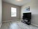 Bright bedroom featuring light gray walls, stylish wood flooring, and a large window for natural light at 25168 E Lenox Cir, Punta Gorda, FL 33950
