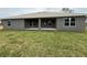 A home's backyard featuring a covered patio area and a lush green lawn, creating a relaxing outdoor space at 49 Tee View Rd, Rotonda West, FL 33947