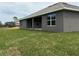 Side view of a single-story home featuring a covered patio and well-manicured lawn at 49 Tee View Rd, Rotonda West, FL 33947