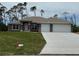 Beautiful single-story home featuring an attached two-car garage and well-maintained lawn at 49 Tee View Rd, Rotonda West, FL 33947