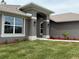 Home's entry with manicured landscaping, stucco columns, and wall-mounted lights at 49 Tee View Rd, Rotonda West, FL 33947
