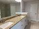 Modern bathroom featuring double sinks, granite countertops, and a tiled shower with glass door at 8347 Ada St, Port Charlotte, FL 33981
