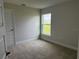 Well-lit bedroom with neutral paint, plush carpeting, and a large window overlooking the yard at 8347 Ada St, Port Charlotte, FL 33981