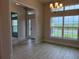 Bright living room featuring tile floors, chandelier lighting, and large windows with natural light at 8347 Ada St, Port Charlotte, FL 33981