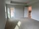 Bright main bedroom featuring tray ceiling, plush carpeting, and a private door to the backyard at 8347 Ada St, Port Charlotte, FL 33981