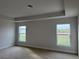 Spacious main bedroom with tray ceiling, plush carpeting, and large windows overlooking the yard at 8347 Ada St, Port Charlotte, FL 33981