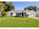 Single-story home with white exterior, two car garage and well maintained lawn at 22058 Seaton Ave, Port Charlotte, FL 33954