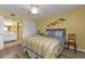 Cozy bedroom with striped bedding, wood floors, and adjacent bathroom at 150 Harborside Ave # 216, Punta Gorda, FL 33950