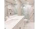 Bathroom with a frameless shower, white vanity, and marble tile at 200 Harbor Walk Dr # 243, Punta Gorda, FL 33950