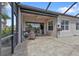 Inviting outdoor patio with stone pavers, screened-in lanai, and access to the home's interior at 13064 Creekside Ln, Port Charlotte, FL 33953