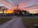 Charming homes are showcased against a vibrant sunset backdrop in this tranquil neighborhood setting at 743 Tangerine Woods Blvd, Englewood, FL 34223