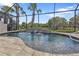 Inviting kidney-shaped pool with a waterfall feature and screened enclosure at 13064 Creekside Ln, Port Charlotte, FL 33953