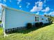 Side view of the house showcasing its light blue siding and landscaping at 743 Tangerine Woods Blvd, Englewood, FL 34223