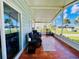 Screened porch with tiled floor, wicker chairs, and a view at 743 Tangerine Woods Blvd, Englewood, FL 34223
