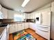 Modern kitchen with white cabinets, stainless steel appliances, and wood floor at 743 Tangerine Woods Blvd, Englewood, FL 34223