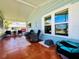 Relaxing screened porch with tile floor, wicker chairs, and a pet carrier at 743 Tangerine Woods Blvd, Englewood, FL 34223