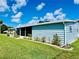 Side view of the house showcasing its light blue siding and landscaping at 743 Tangerine Woods Blvd, Englewood, FL 34223