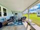 Relaxing screened porch with wicker furniture and view of the yard at 743 Tangerine Woods Blvd, Englewood, FL 34223