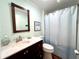 Clean bathroom with dark vanity, shower, and white toilet at 743 Tangerine Woods Blvd, Englewood, FL 34223