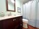 Clean bathroom with dark vanity, shower, and white toilet at 743 Tangerine Woods Blvd, Englewood, FL 34223