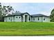 Single-story home with light green exterior, landscaping, and a two-car garage at 5148 Guava Ter, Port Charlotte, FL 33981