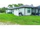 Home's rear showcasing a pool, screened patio, and a large grassy area at 5148 Guava Ter, Port Charlotte, FL 33981