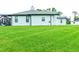 Rear view of house with a large lawn and screened patio at 5148 Guava Ter, Port Charlotte, FL 33981