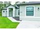 Partial view of a light green house with walkway and landscaping at 5148 Guava Ter, Port Charlotte, FL 33981