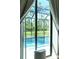 View from bedroom showcases a pool and lush green landscape beyond the sliding glass doors at 5148 Guava Ter, Port Charlotte, FL 33981