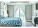 Main bedroom with blue bedding, sliding glass doors, and wood-look tile floors at 5148 Guava Ter, Port Charlotte, FL 33981