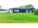 Back of house, featuring a large screened patio and expansive lawn at 5148 Guava Ter, Port Charlotte, FL 33981