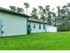 Light green house exterior showcasing a well-maintained lawn and privacy fence at 5148 Guava Ter, Port Charlotte, FL 33981