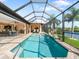 Screened-in pool area with beautiful blue water, lounge chairs, and access to outdoor dining at 15378 Taurus Cir, Port Charlotte, FL 33981