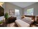 Cozy bedroom features a bed with a wooden headboard, large windows, and closet at 2513 Elkcam Blvd, Port Charlotte, FL 33952