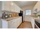 Modern kitchen features white cabinets, granite countertops, and stainless steel appliances at 2513 Elkcam Blvd, Port Charlotte, FL 33952